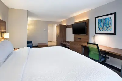 a hotel room with a bed and a flat screen tv at Holiday Inn Express Hotel & Suites Delaware-Columbus Area by IHG in Sunbury