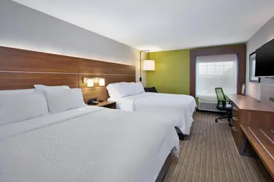 a hotel room with two beds and a flat screen tv at Holiday Inn Express Hotel & Suites Delaware-Columbus Area by IHG in Sunbury