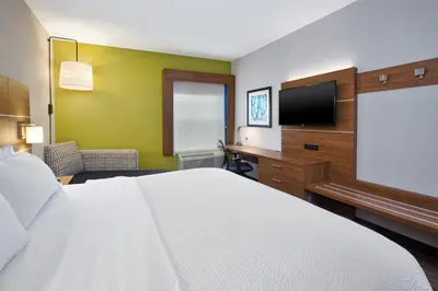 a hotel room with a bed and a flat screen tv at Holiday Inn Express Hotel & Suites Delaware-Columbus Area by IHG in Sunbury