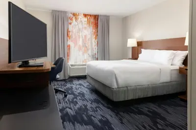 a hotel room with a bed and a flat screen tv at Fairfield Inn and Suites by Marriott Cincinnati Eastgate in Eastgate