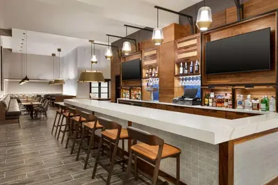 a bar in a restaurant with a long counter and chairs at Doubletree By Hilton Columbus Dublin in Dublin