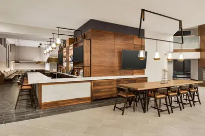 a kitchen with a table and a bar with chairs at Doubletree By Hilton Columbus Dublin in Dublin