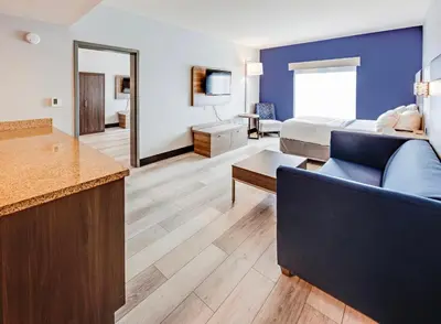 a hotel room with a bed and a living room at Holiday Inn Express Hotel & Suites Ohio State University- OSU Medical Center by IHG in Columbus