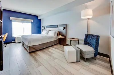a hotel room with a bed and a chair at Holiday Inn Express Hotel & Suites Ohio State University- OSU Medical Center by IHG in Columbus