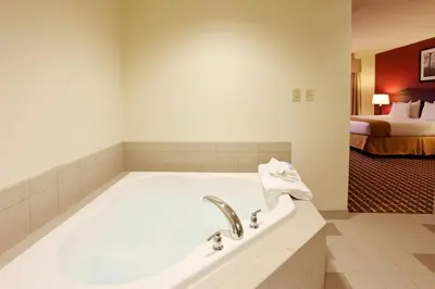 a bathroom with a bath tub with a bed at Holiday Inn Express Hotel & Suites Ohio State University- OSU Medical Center by IHG in Columbus