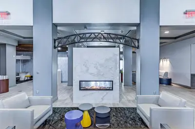 a lobby with two white couches and a fireplace at Holiday Inn Express Hotel & Suites Ohio State University- OSU Medical Center by IHG in Columbus