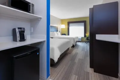 a hotel room with two beds and a bathroom at Holiday Inn Express Hotel & Suites Woodhaven by IHG in Woodhaven