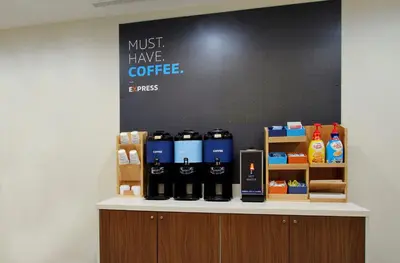 a counter with bottles of coffee on it at Holiday Inn Express Hotel & Suites Cincinnati Southeast Newport by IHG in Bellevue