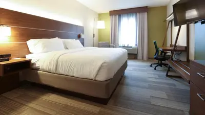 a hotel room with a large bed and a desk at Holiday Inn Express Hotel & Suites Cincinnati Southeast Newport by IHG in Bellevue
