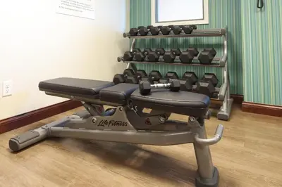 a gym with a row of exercise equipment at Holiday Inn Express Hotel & Suites Cincinnati Southeast Newport by IHG in Bellevue