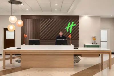 a man standing in front of a reception desk at Holiday Inn Florence by IHG in Florence
