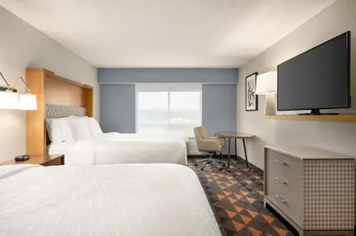 a hotel room with two beds and a flat screen tv at Holiday Inn Florence by IHG in Florence