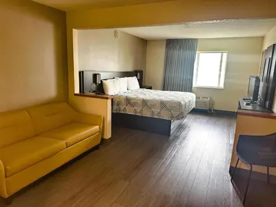 a hotel room with a bed and a couch at Motel 6-Anderson, IN in Anderson