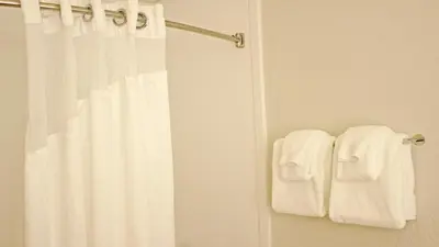 a bathroom with a shower curtain and two towels at Holiday Inn Express Winfield - Teays Valley by IHG in Hurricane