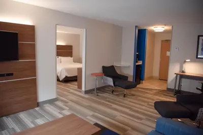 a hotel room with a bedroom and a bed at Holiday Inn Express Winfield - Teays Valley by IHG in Hurricane