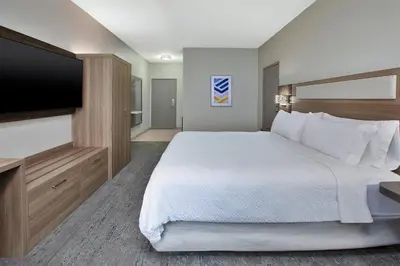 a hotel room with a large bed and a flat screen tv at Holiday Inn Express Hotel & Suites Wauseon by IHG in Wauseon