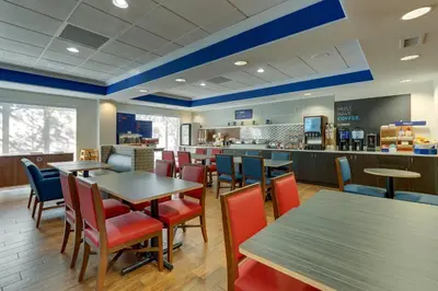 a restaurant with tables and chairs and a counter at Holiday Inn Express Hotel & Suites Dayton-Centerville by IHG in Centerville