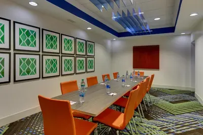 a conference room with a long table and orange chairs at Holiday Inn Express Hotel & Suites Dayton-Centerville by IHG in Centerville