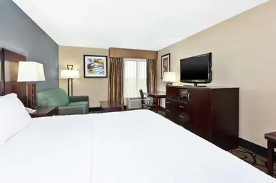 a hotel room with a bed and a flat screen tv at Hampton Inn Monroe in Monroe