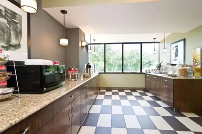 a large kitchen with a checkered floor at Hampton Inn New Philadelphia in New Philadelphia