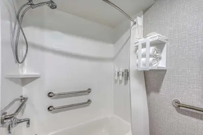 a white bathroom with a shower and a sink at Hampton Inn New Philadelphia in New Philadelphia