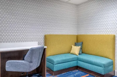 a room with two chairs and a couch and a desk at Hampton Inn New Philadelphia in New Philadelphia