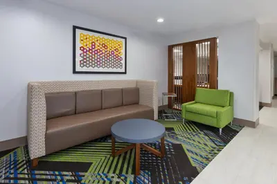 a living room with a couch and a green chair at Holiday Inn Express & Suites Dayton South Franklin by IHG in Franklin