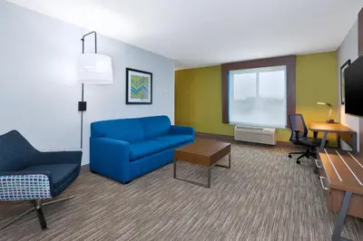 a living room with a blue couch and a tv at Holiday Inn Express & Suites Dayton South Franklin by IHG in Franklin