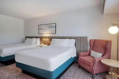 a hotel room with two beds and a chair at Hilton Garden Inn Clarksburg in Clarksburg