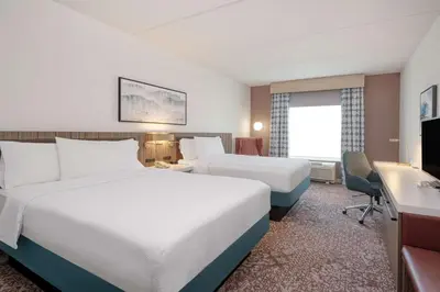 a hotel room with two beds and a desk at Hilton Garden Inn Clarksburg in Clarksburg