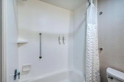 a white bathroom with a tub and a shower at Hilton Garden Inn Clarksburg in Clarksburg
