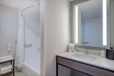 a bathroom with a sink and a shower with a mirror at Hilton Garden Inn Clarksburg in Clarksburg