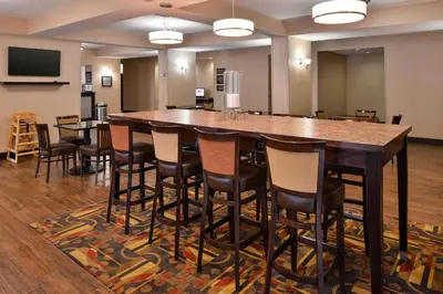 a large bar in a large room with chairs at Wingate by Wyndham Steubenville in Steubenville