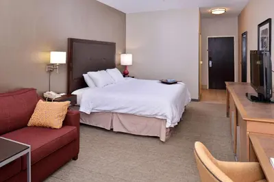 a hotel room with a bed and a couch at Wingate by Wyndham Steubenville in Steubenville