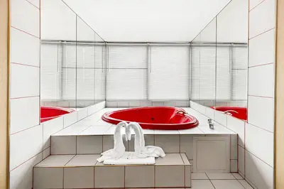 a bathroom with a red tub and two red sinks at Quality Inn Dayton Airport in Englewood