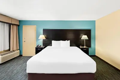 a large white bed in a room with blue walls at Quality Inn Dayton Airport in Englewood