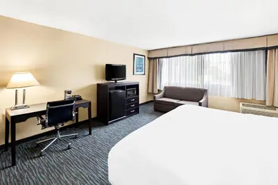 a hotel room with a bed and a desk and a chair at Quality Inn Dayton Airport in Englewood