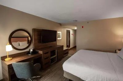 a hotel room with a bed and a mirror at Hampton Inn Springfield in Springfield