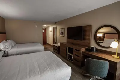 a hotel room with a bed and a mirror at Hampton Inn Springfield in Springfield