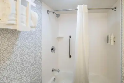a bathroom with a shower with a shower curtain at Hampton Inn Springfield in Springfield