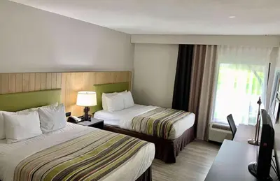 a hotel room with two beds and a window at Country Inn & Suites by Radisson, Sandusky South, OH in Milan