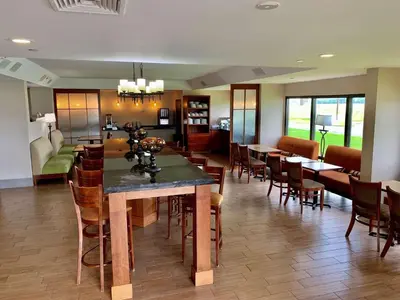 a dining room and living room with a table and chairs at Country Inn & Suites by Radisson, Sandusky South, OH in Milan