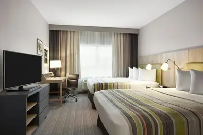 a hotel room with two beds and a flat screen tv at Country Inn & Suites by Radisson, Sandusky South, OH in Milan