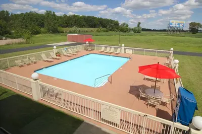 an overhead view of a swimming pool with a red umbrella at Country Inn & Suites by Radisson, Sandusky South, OH in Milan