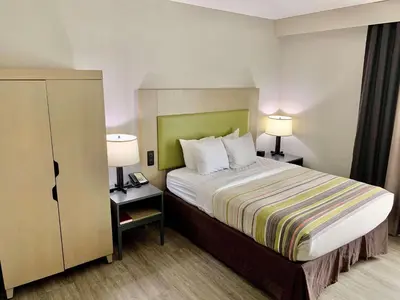 a hotel room with a bed and two lamps at Country Inn & Suites by Radisson, Sandusky South, OH in Milan