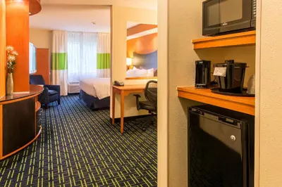a hotel room with a bedroom with a bed and a desk at Fairfield Inn & Suites Canton in North Canton