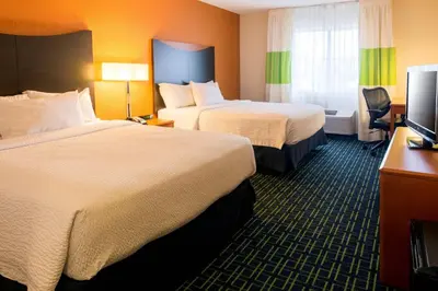 a hotel room with two beds and a television at Fairfield Inn & Suites Canton in North Canton