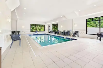 a swimming pool in a house with chairs and a table at Hampton Inn Washington in Washington