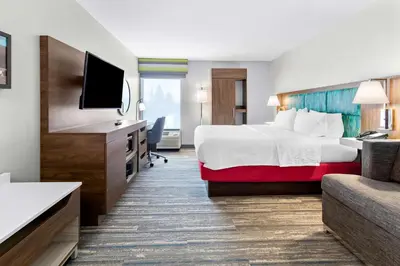a hotel room with a bed and a flat screen tv at Hampton Inn Washington in Washington