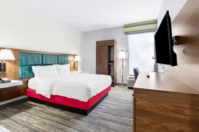 a hotel room with a bed and a flat screen tv at Hampton Inn Washington in Washington